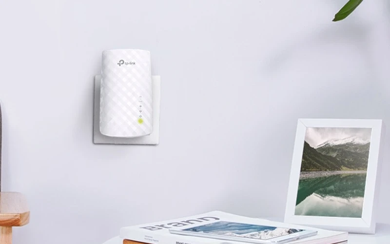 Repetidor de Sinal TP-Link Mesh AC750 branco conectado à tomada da casa