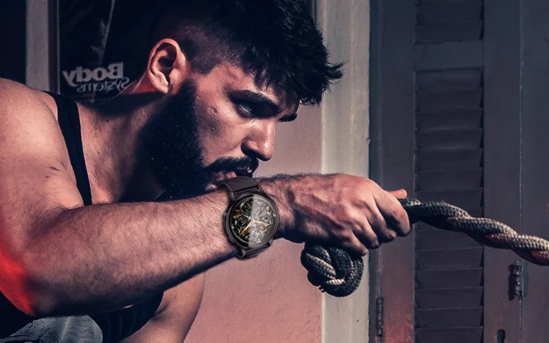 Homem praticando esporte com smartwatch Kumi GW5 no pulso.